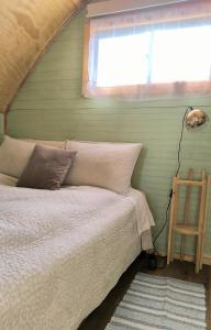 a bed in a room with a window and a lamp at Elimar Ocean View in Valdivia