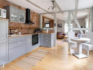 a kitchen with white cabinets and a table and a dining room at Alma in Zierow