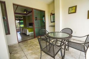 a dining room with a glass table and chairs at Hotel y Suites Los Encantos in Sayulita