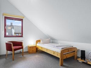 a bedroom with a bed and a chair and a window at Seestrasse 35 in Insel Poel