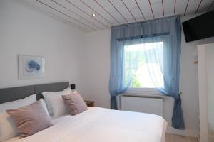 a bedroom with a white bed and a window at Blue Lagoon Holiday Apartments & Double Room with Balcony in Nehren