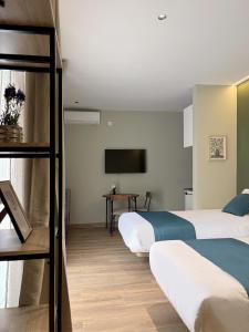 a hotel room with two beds and a television at Feliz Apartment in Madrid