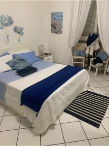 a bedroom with a bed with a blue blanket on it at Appartamento ANGIE in Forio d'Ischia