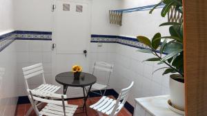 a dining room with a table and white chairs at La Rose in Gandía