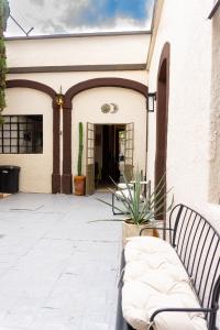 a patio with two benches in front of a building at Casa del Patio in Guadalajara