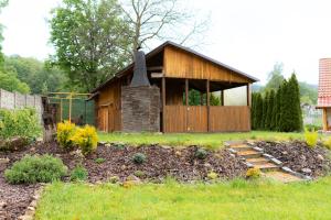 a small house with a fireplace in a yard at Chaloupka nedaleko Monínce in Sušetice