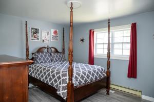 ein Schlafzimmer mit Himmelbett und Fenster in der Unterkunft Exceptional Ocean View Hillview in Northern Bight
