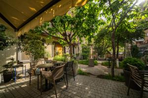 eine Terrasse mit Tisch und Stühlen und Bäumen in der Unterkunft MIST Boutique Hotel in Yerevan