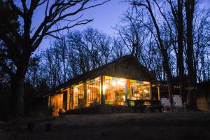 a house lit up at night with lights at El Escondido Natural Glamp in Atos Pampa