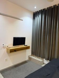 a bedroom with a bed and a tv and curtains at SM residence in Lahore