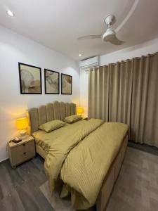 a bedroom with a large bed with two lamps on it at SM residence in Lahore