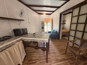 a kitchen with a table and a living room at Fare Maeva in Paopao
