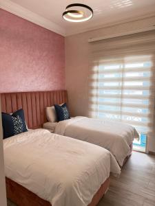 a bedroom with two beds and a window at Cozy appartement smir park in Tétouan +16 photos
