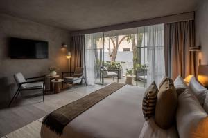 a hotel room with a large bed and a balcony at Casa Levora in Mexico City