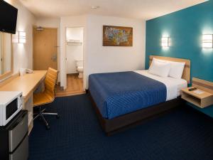 a hotel room with a bed and a desk and a computer at Econo Lodge Menomonie in Menomonie