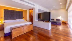 a bedroom with a large bed and a flat screen tv at Barceló Monterrey Valle in Monterrey