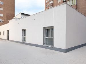 a white building with barred windows on the side of it at Feliz Apartment in Madrid
