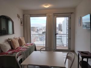a living room with a couch and a table and a window at APA Centro 2505 - con hidromasaje in Puerto Madryn +12 photos