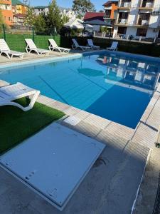 a large swimming pool with lounge chairs at Hotel Mia in Ureki