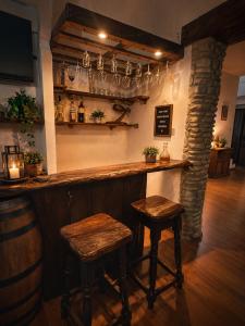 a bar with two stools and a counter with glasses at Bellavista B&B in Roccavivara