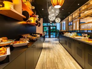 a kitchen with a long counter with food on it at Novotel Suites Reims Centre in Reims