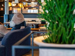 a teddy bear sitting in a chair in a restaurant at Novotel Suites Reims Centre in Reims