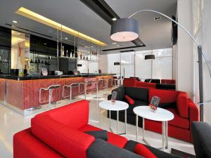 a living room with red furniture and a bar at Ibis Bangkok Sukhumvit 4 in Bangkok