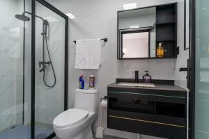 a bathroom with a toilet and a sink and a shower at Spectacular 3 bedroom apartment in Syokimau +18 photos