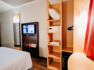 a room with a bed and a tv in a room at ibis Asuncion in Asunción +101 photos