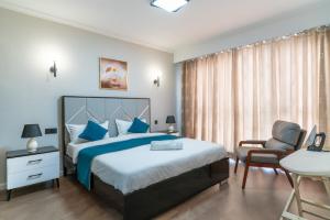 a bedroom with a large bed and a chair at Spectacular 3 bedroom apartment in Syokimau