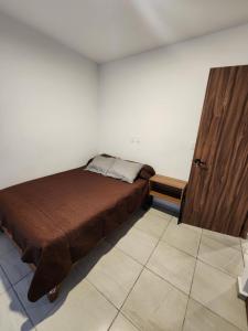 ein Schlafzimmer mit einem Bett und einer Holztür in der Unterkunft Depa Piky in La Cañada