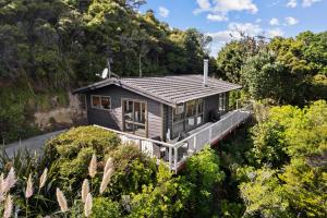 a house on a deck in the middle of trees at Island view Experience in Coromandel Town