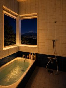 a bathroom with a tub with a view of a mountain at Fuji Nest Izu in Izunokuni +23 photos