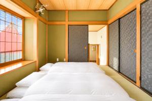 a bedroom with two beds and a window at Fuji Nest Izu in Izunokuni