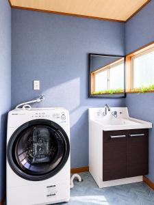 a washing machine in a bathroom with a sink at Fuji Nest Izu in Izunokuni