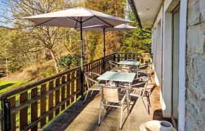 a patio with tables and chairs and an umbrella at Le Petit Verger in Waimes +22 photos