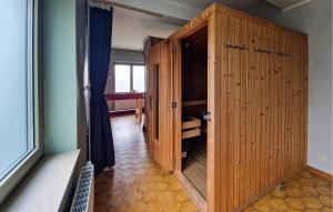 a large wooden cabinet in a room with a window at Le Petit Verger in Waimes