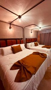 two beds in a hotel room with white sheets at Hotel Van Gogh Aeropuerto Gdl in Guadalajara