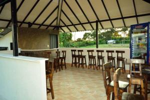 a restaurant with a bar with chairs and tables at FINCA HOTEL GUADUAL Quindío in Quimbaya