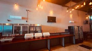 a kitchen with a bar with white chairs at Hotel Van Gogh Aeropuerto Gdl in Guadalajara