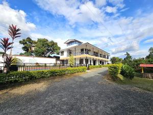 a large white house with a fence in front of it at FINCA HOTEL GUADUAL Quindío in Quimbaya