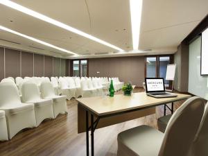 a conference room with white chairs and a table with a laptop at Mercure Bali Nusa Dua in Nusa Dua +138 photos