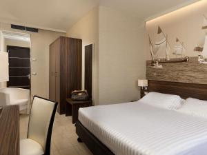 a hotel room with a bed and a bathroom at Mercure Rimini Lungomare in Rimini