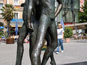 a woman walking past a statue of a person at ibis budget Aachen City in Aachen
