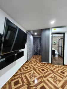 a living room with a large television and wooden floor at FINCA HOTEL GUADUAL Quindío in Quimbaya