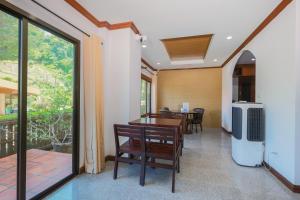 a dining room with a table and chairs and a window at Siray Green Resort in Phuket