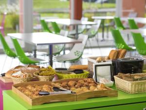 a table topped with a tray of bread and pastries at Ibis Styles Nivelles in Nivelles