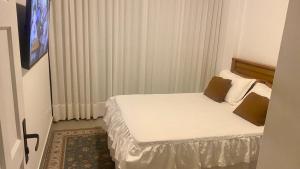 a small bedroom with a bed in a room at Elegância Praia da Sereia in Vila Velha