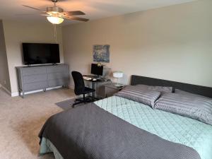a bedroom with a bed and a desk with a computer at Tide's Turn Retreat in Cedar Point