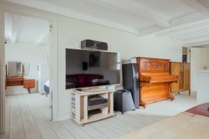 a room with a piano and a room with a bed at Jógvansstova - 2BR House - Explore the North in Leirvík
